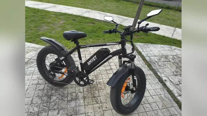 Amyet K10 preta estacionada em calçada, vista de lado