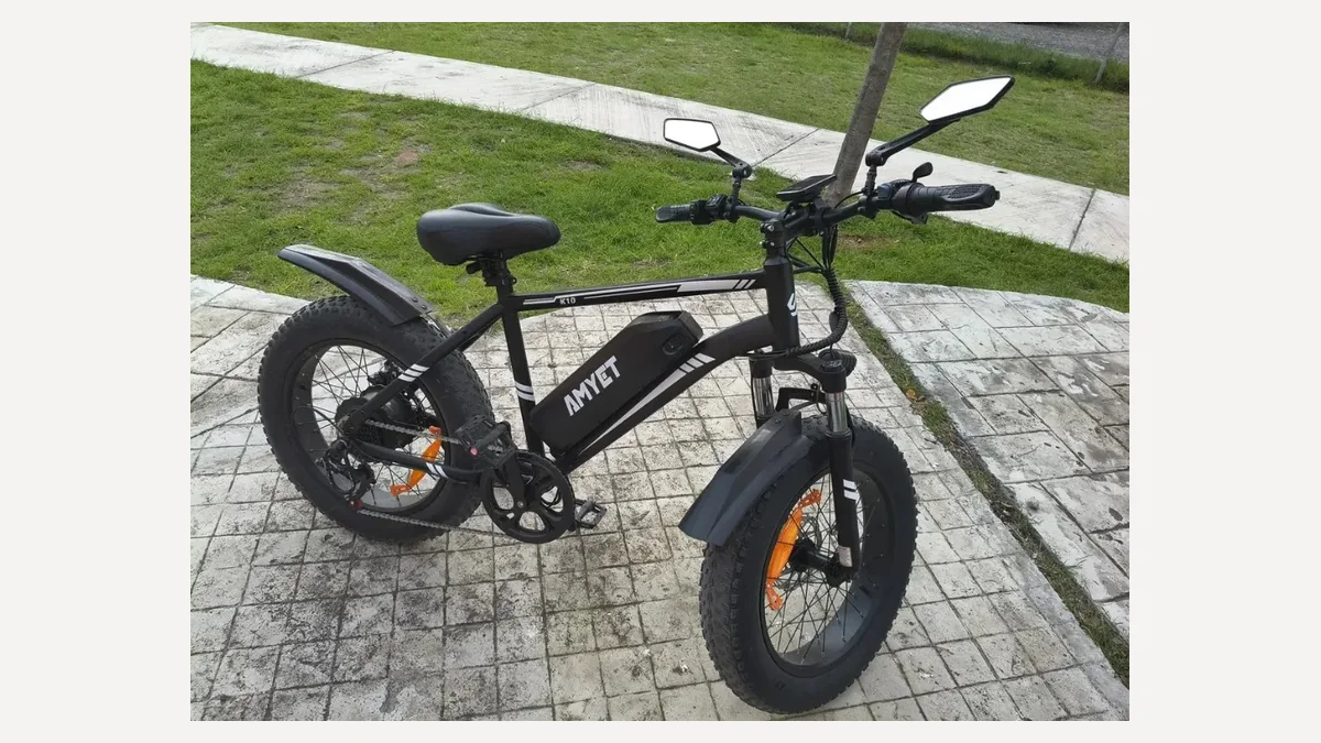 Amyet K10 preta estacionada na calçada, uma bicicleta elétrica 1000W de pneu fat e suspensão dianteira