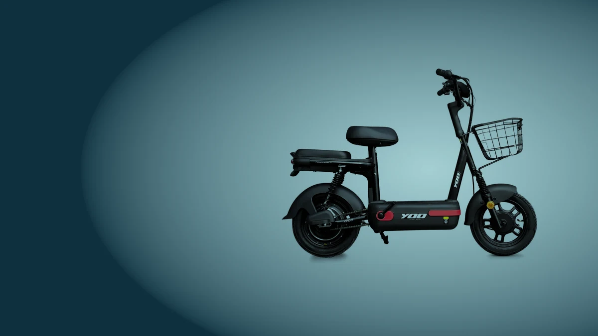 Yoo Mobility Y-200 preta com detalhes vermelhos, de lado, com cesto e banco duplo, sobre fundo azul acinzentado, um dos modelos de bicicleta elétrica barata lidos