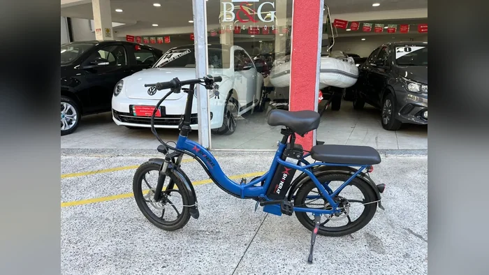 Shineray E-bike azul de lado, em frente a uma loja de veículos