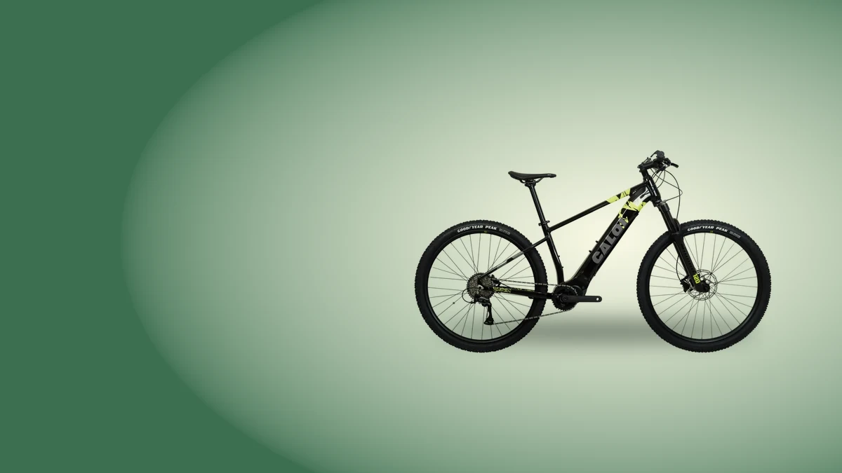 Bicicleta elétrica Caloi E-Vibe Explorer preta de lado sobre fundo verde, um exemplo de e-bike