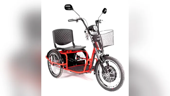 Triciclo elétrico Village Pam vermelho de lado com cesta, banco com encosto e roda dianteira com motor
